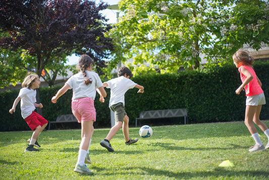 Kids practicing soccer drills on a field using agility cones and training equipment to improve ball control and agility