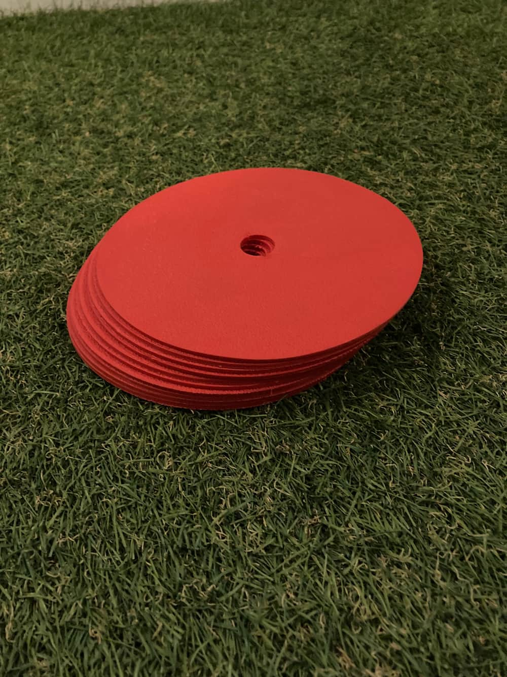 Flat markers spread on a football pitch for footwork and cone drill training